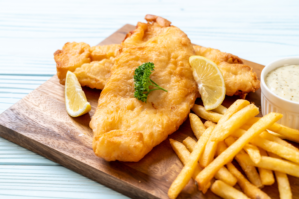 Battered cod and chips on a serving board